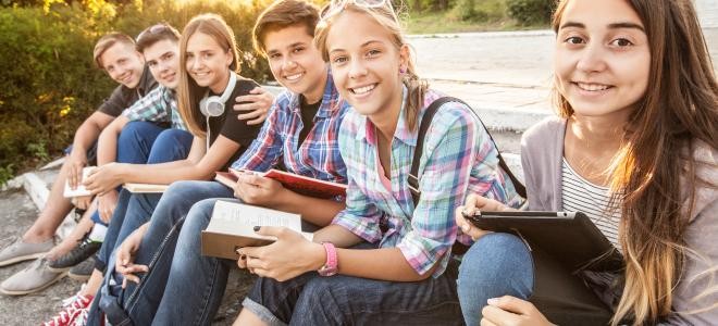 Jugendliche sitzen nebeneinander auf einer Stufe