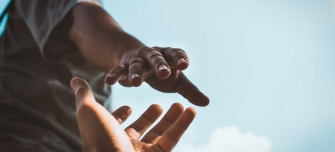 Zwei zueinander gestreckte Hände