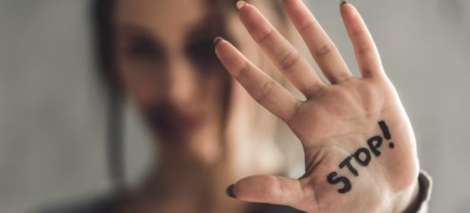 Junge Frau auf deren Handinnenfläche Stop steht